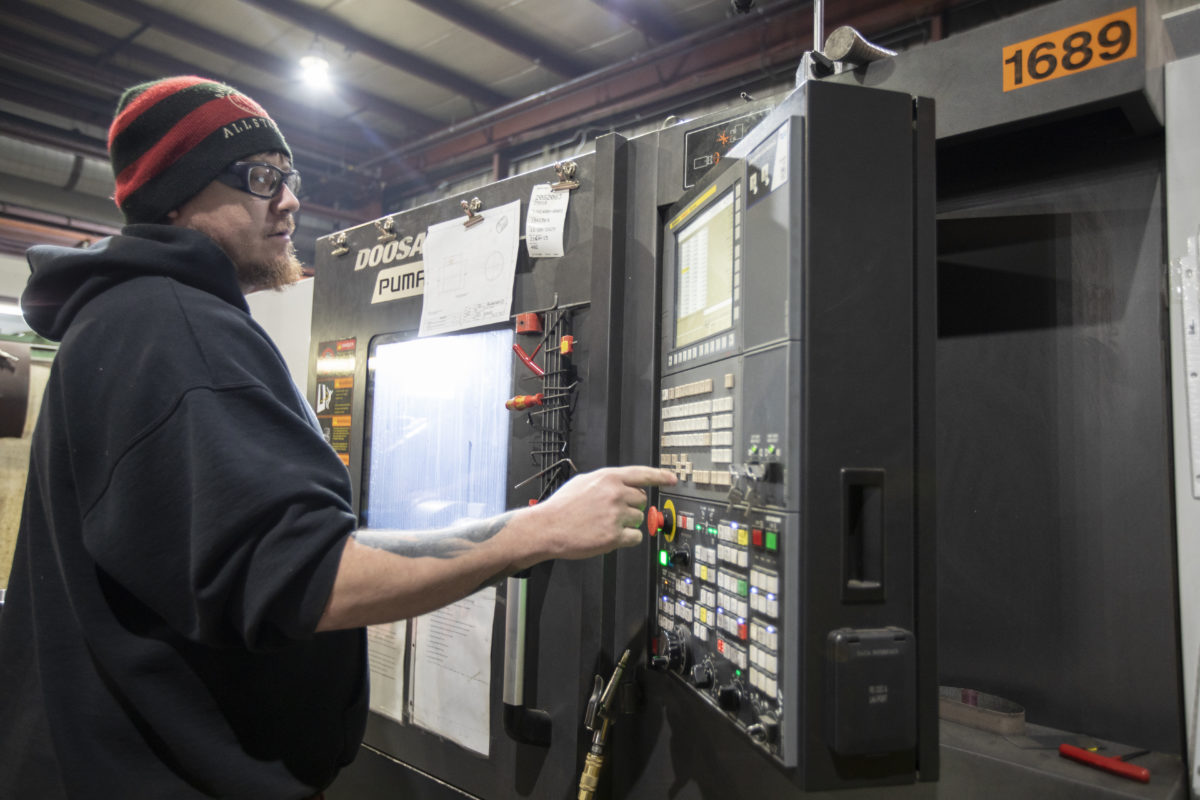 A spuncast employee operating a cnc machine.