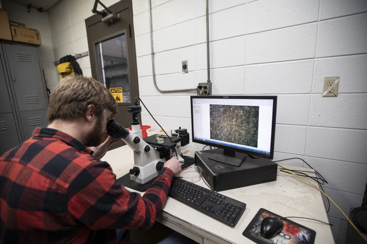 An employee doing metallurgical testing.